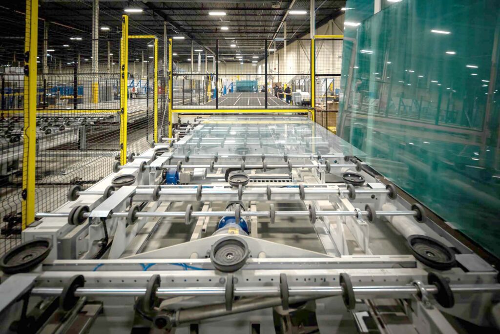 Conveyor rollers transporting glass sheets in fabrication plant