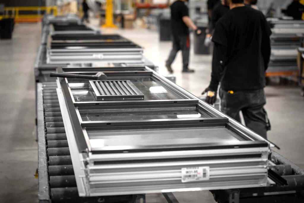 Multiple aluminum window frames stacked and prepared for packaging