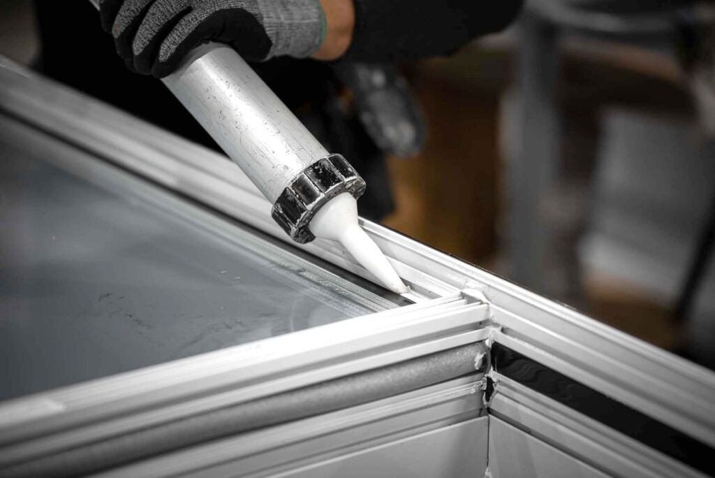 Close-up of silicone bead being applied to window joint