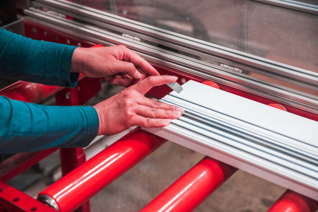 Worker assembling or inspecting aluminum window frame manually