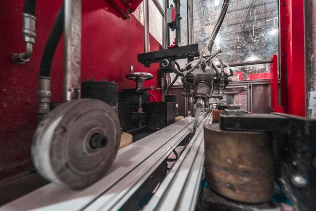 Aluminum profiles advancing through industrial roller system