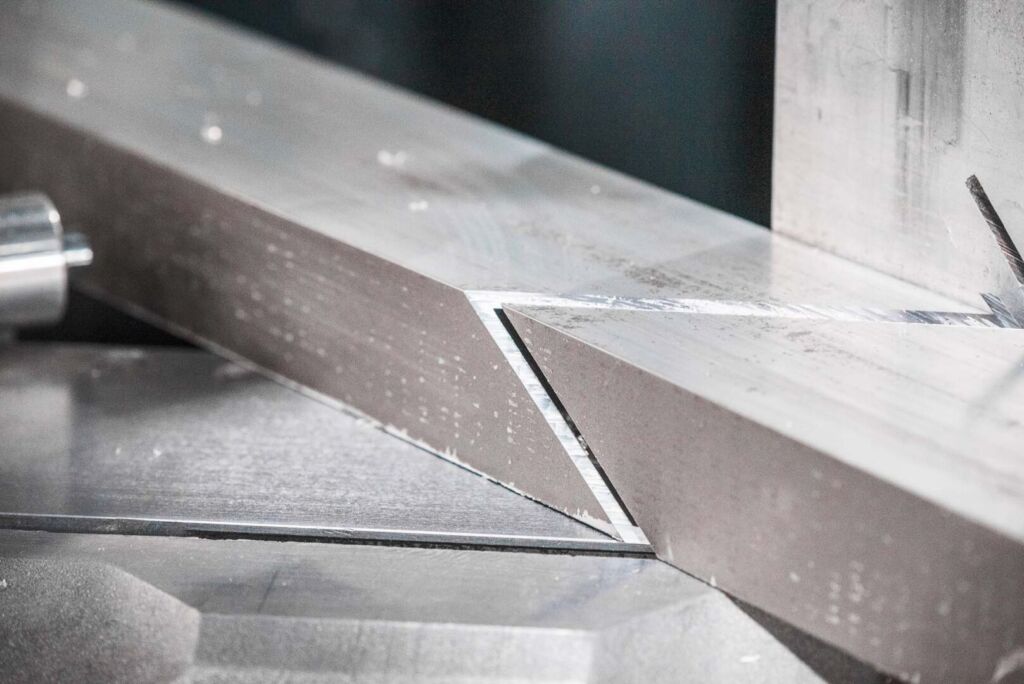 Close-up of aluminum extrusion being mitre cut at angle