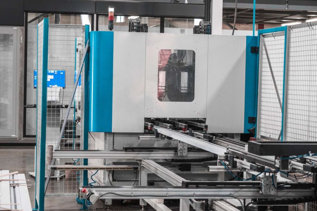 Precision machinery with blue panels preparing aluminum parts