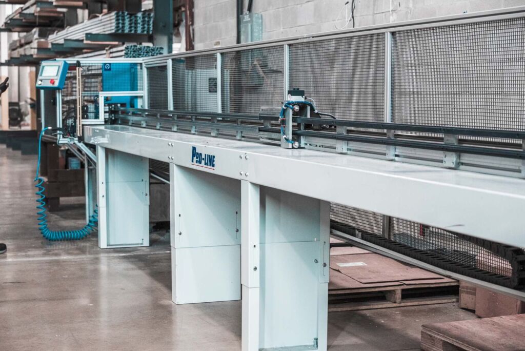 Aluminum window profile being guided through automated cutter