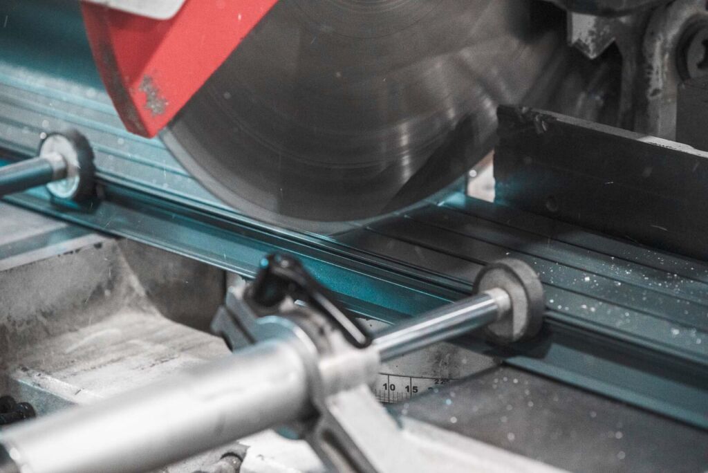 Rotating blade cutting aluminum extrusion on production line